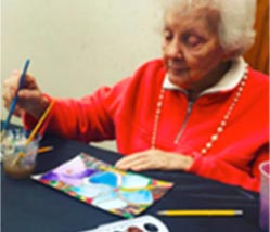 Elderly woman painting with watercolors. Part of a program through Fine Arts Institute of Edmond.